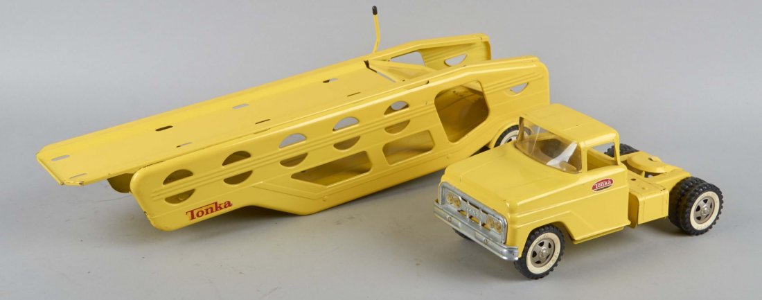 Lot Of 2: Pressed Steel Tonka Motor Transports: 1 - Pressed steel Tonka motor transport with "Tonka" decals on the passenger and driver side doors and trailer. Whitewall wheels are stamped, "Tonka Toys, U.S.A." Cab has plastic windshield. Circa 196