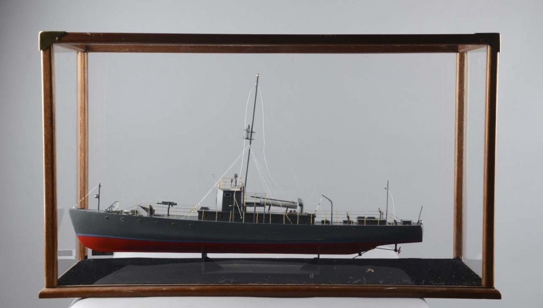 Model Ship In Display Case: This is a model of a military ship. The hull is dark grey and red. There is one gun on deck and one mast with a crows nest that is occupied. The display case is wood and acrylic. Condition (Very Good)