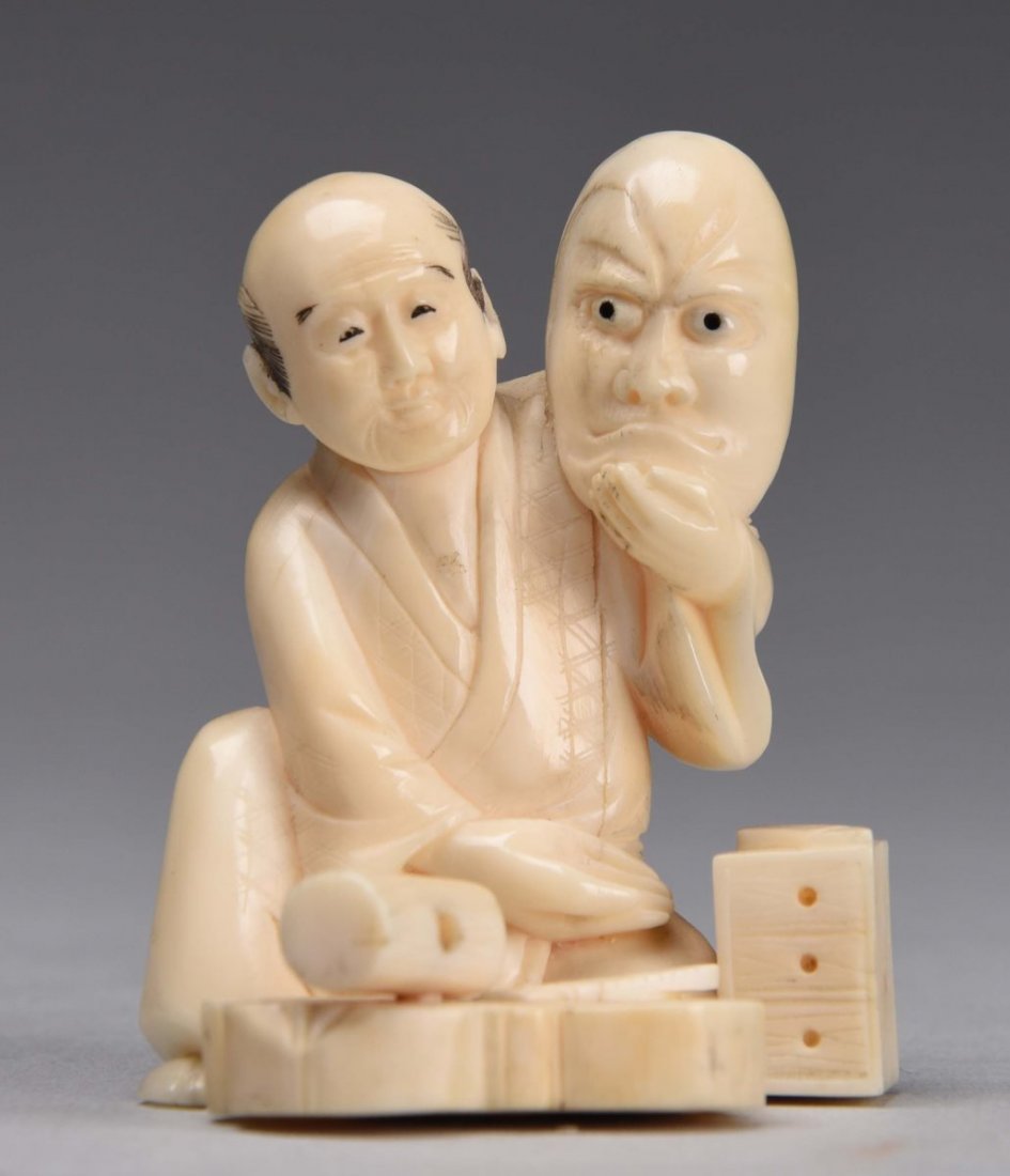 Japanese Ivory Okimono of Man & Head.: Shows a man sitting down holding up a head. Unique carving with no damage Condition (Near Mint). Size 2-1/2'' T.