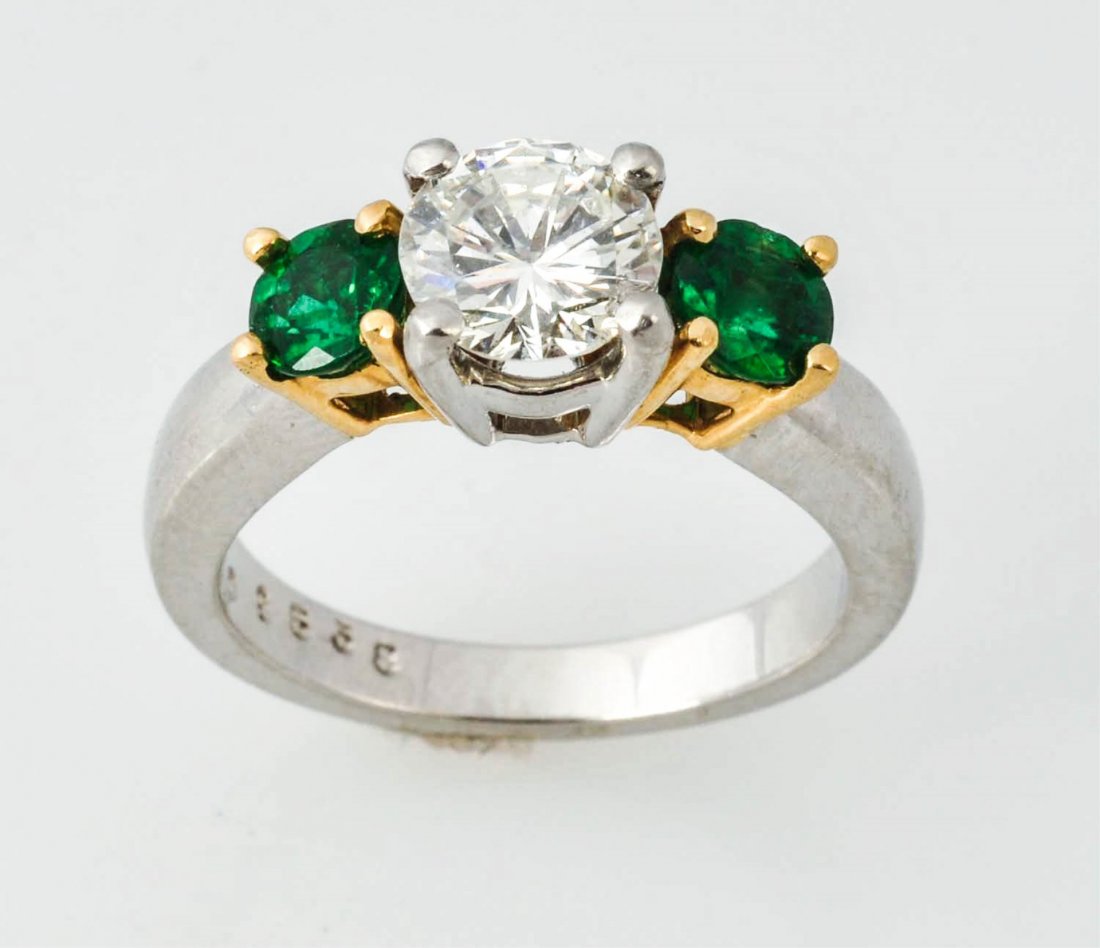 Diamond Solitaire With Martin Flyer Mounting.: RBC approximately 1.04 cts. Approximately I, SI2. Two round emeralds approximately .70 cts TW. Martin Flyer platinum and 18K mounting.5.1 dwts. Size 6.
