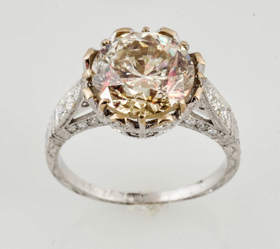 4.28 ct. Clarity Enhanced Solitaire.: RBC diamond, light cape color. 18K. RBC diamonds approximately .75 cts TW. 2.7 dwt. Size 6-3/4.