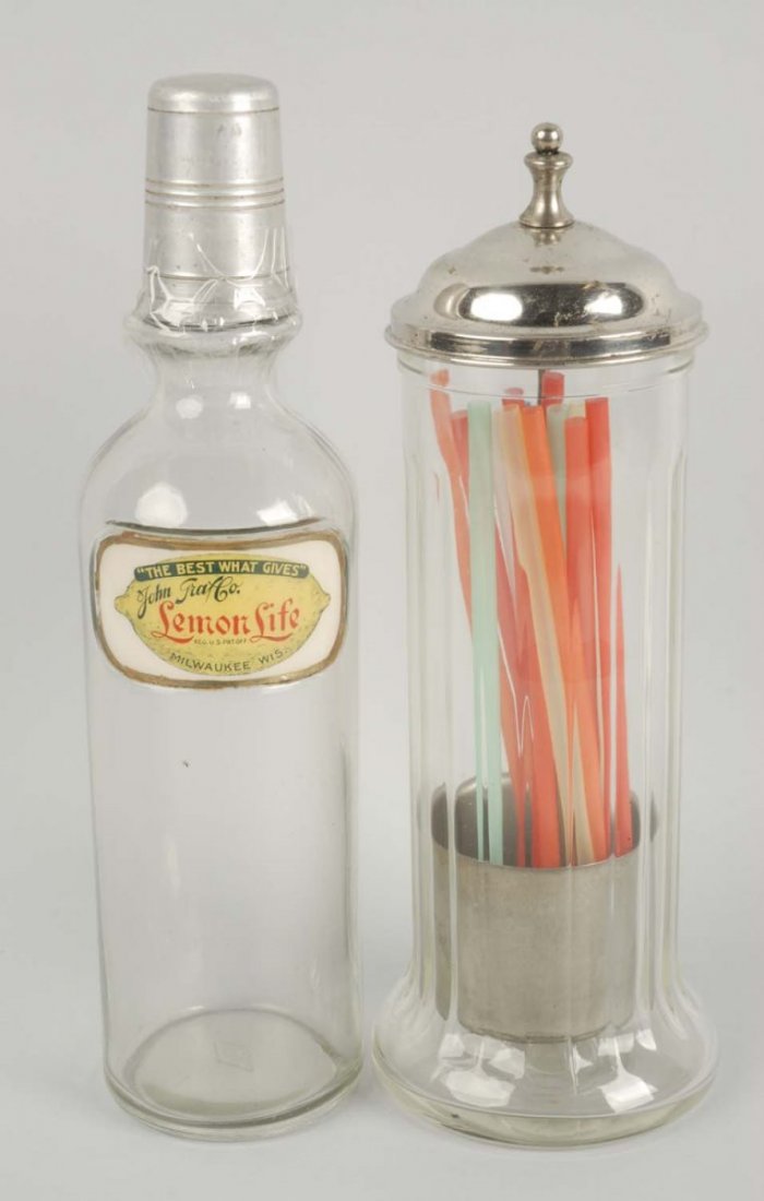 Lot Of 2: Soda Fountain Items.: This lot includes a very nice Lemon Life syrup bottle and a glass straw holder with original lid and lifter insert. Condition (Excellent). Size 12'' T.