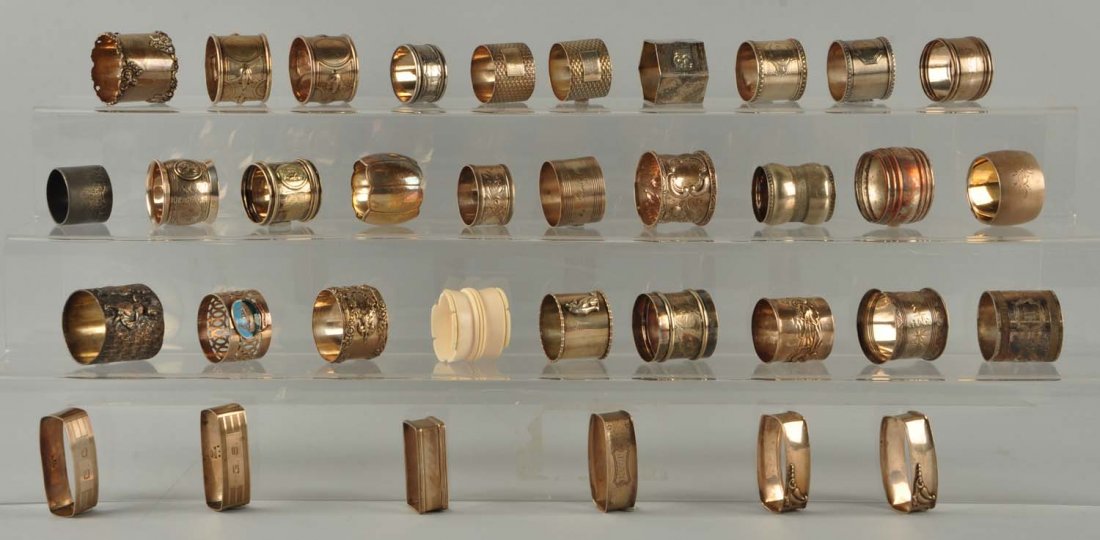Lot Of 35: Non-Figural Napkin Rings.: this lot of non-figural napkin rings includes 7 marked sterling (including a souvenir enameled applique from "SS Viceroy of India;" and one which appears to be some kind of bone. Of the silver plated 