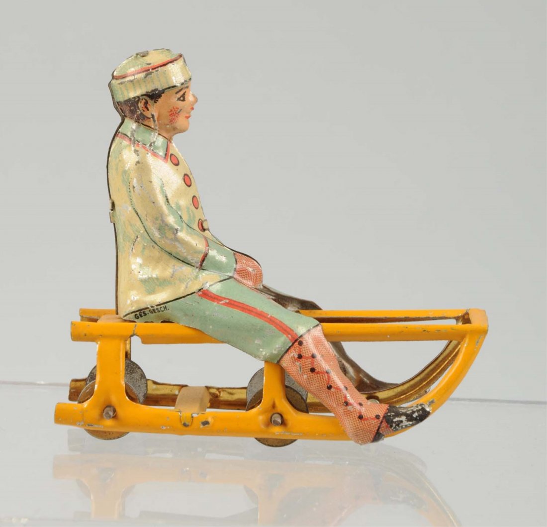 German Tin Litho Boy on Sled Penny Toy. (1 of 2)