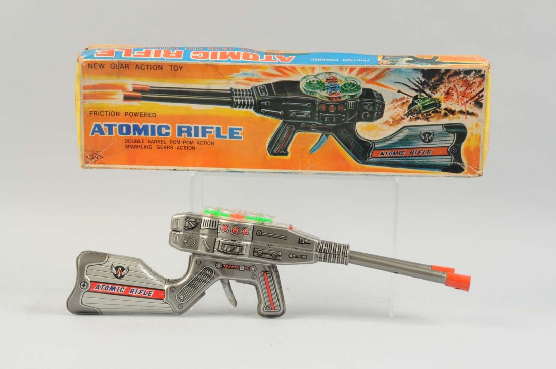 Japanese Tin Litho Atomic Rifle In Box.: Original box with nice color graphics on lid. Made by S.H. Japan. Box does have some creasing and wear. Only minor wear to gun. Mostly tin litho with plastic gearing on top. Condition (Very Good-Excel