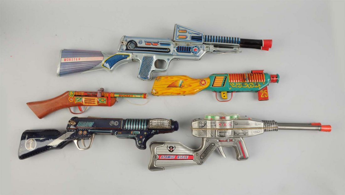 Lot of 5: Japanese Tin Litho Space Rifles.: Very nice lot. Friction and battery operated. One has "Monster" written on the gun butt. Another has "Atomic Rifle" with gears on the top. One marked "Rocket". One has an Indian design and the last ha