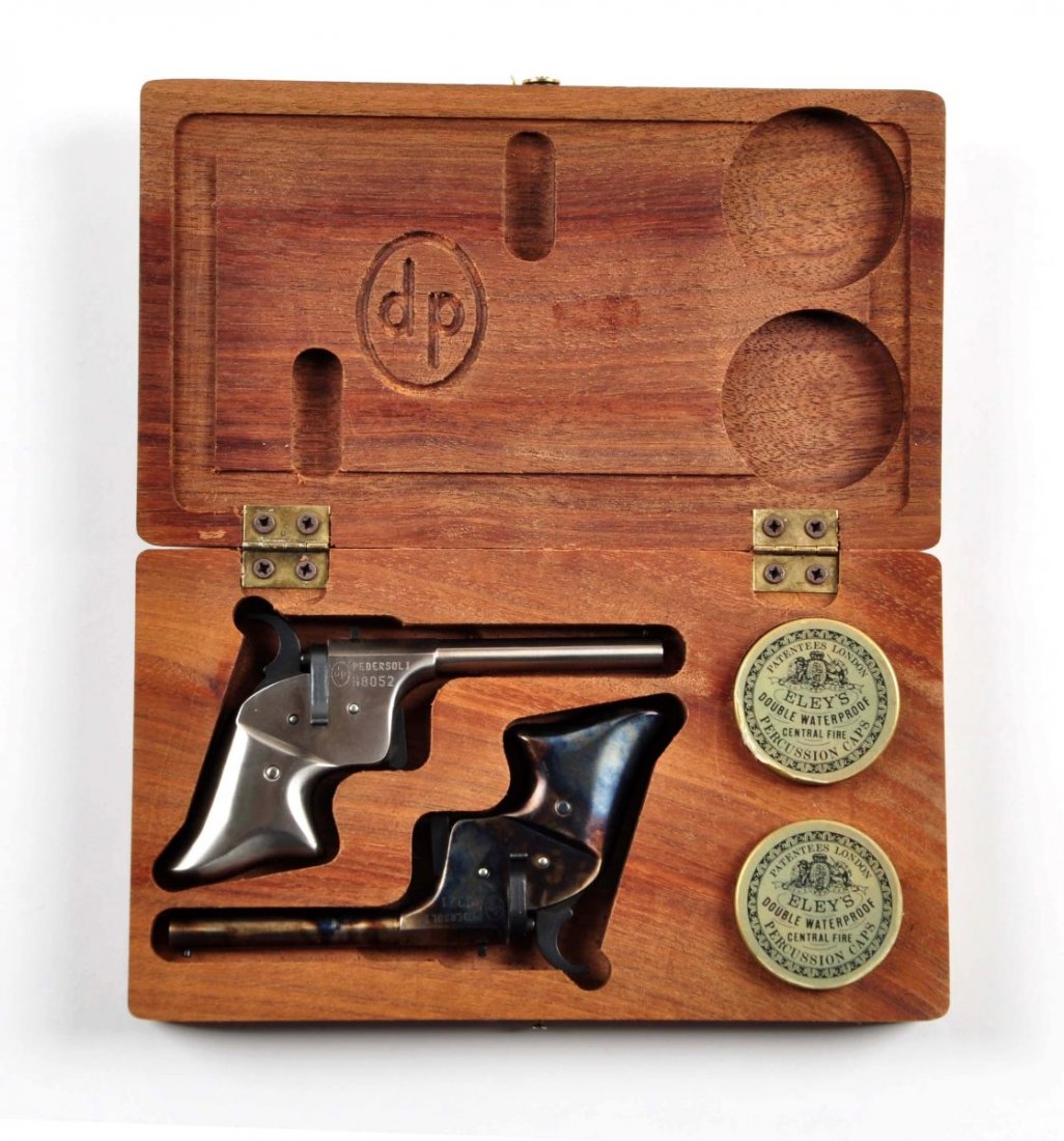 Cased Pair Pedersoli Remington Pistols (A).: Serial # H8052 & H8371 This pair of single shot spur trigger pistols were manufactured by Pedersoli and are similar to the Remington vest pocket pistol made from 1865-1888. They are made to fire BBs p