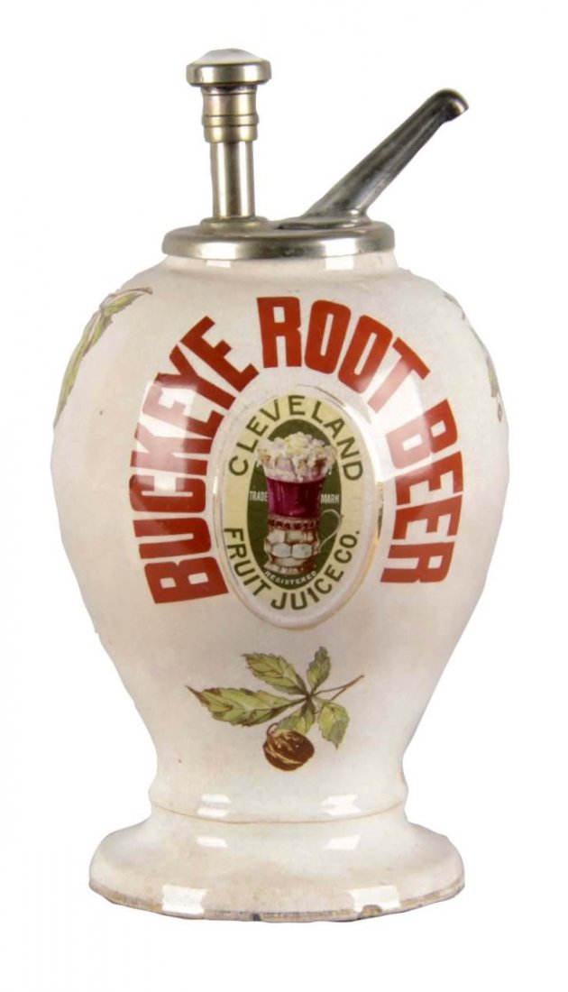 Buckeye Root Beer Dispenser: Tear drop shaped porcelain Buckeye Root Beer syrup dispenser. Dispenser has several illustrations of buckeyes and metallic trim painted around the logo, which has faded in some areas. The base is slig