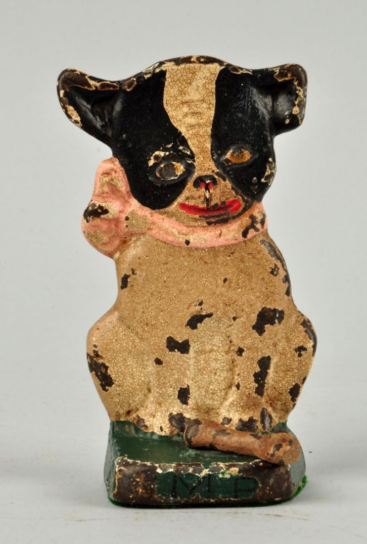 Cast Iron Imp & His Bone Dog Child’s Doorstop.: Made by Hubley, cat. #132. Signed, “Imp” on front of base, on back “GR ©” (Grace Radnor). Has original bone. Book example. Condition (Good). Size 5-1/4'' T.