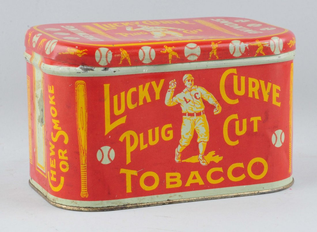 Lucky Curve Plus Cut Tobacco Tin.: This tin has wonderful baseball graphics. There is some mild wear with some dents and paint flecks. Condition (Very Good). Size 4 - 1/4" T.