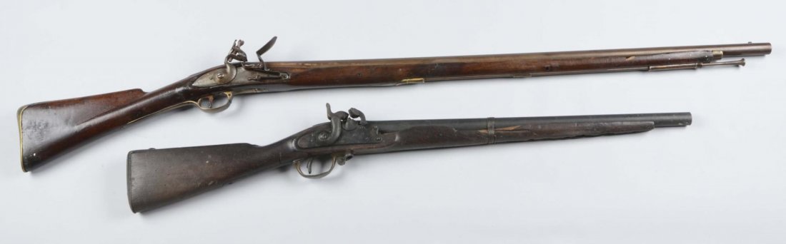 Lot of 2: (A) Musket & Carbine.: Serial # NSV, 245 Comprised of: Gun 1) Flintlock musket. NSV. Total length of 55” with a 39” smooth barrel and 3/4 “bore. Ramrod, brass trigger rod. Stock has 1-1/2” hole on the underside. Mis
