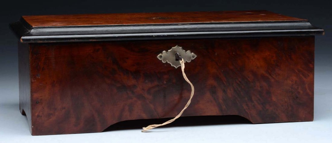Swiss 6 Air Cylinder Music Box.: Carpathian elm veneered music box. It plays six airs on twenty-nine teeth. The tune sheet is present and it is in operation at time of inspection. Condition (Excellent). Size 11-3/4'' L.