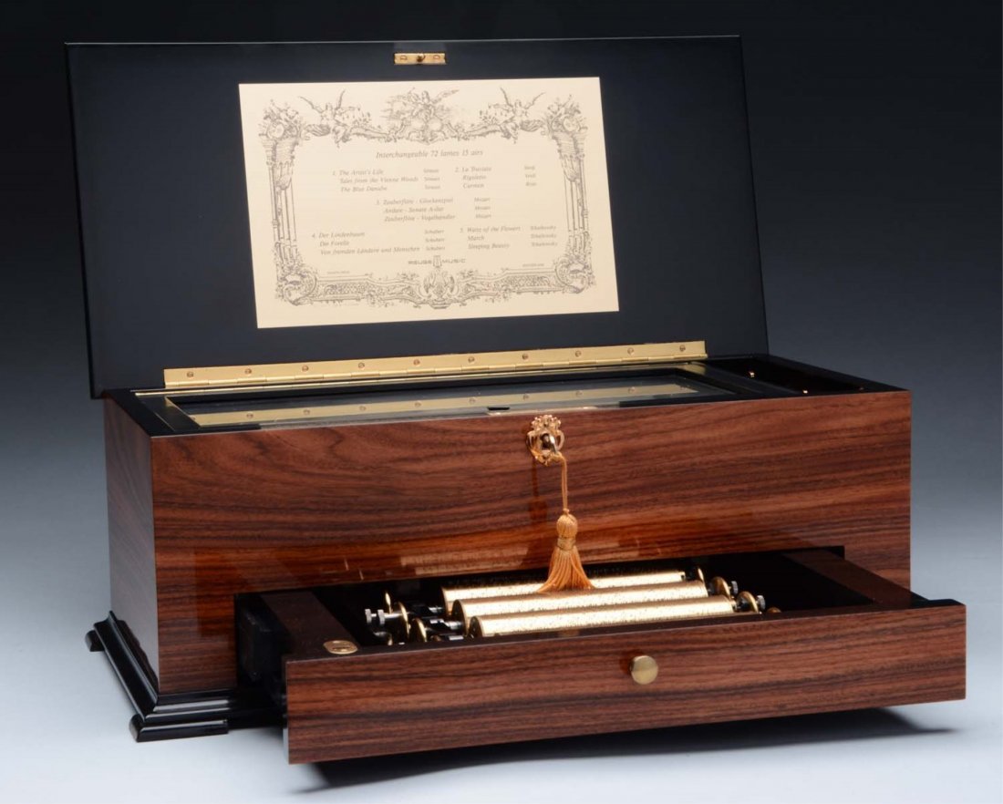 Reuge Interchangeable Cylinder Music Box.: Plays three airs per cylinder on five cylinders. Seventy-two teeth. Has a hidden latch to cylinder drawer, located within musical movement area of case. The tune sheet is present and is in operating c