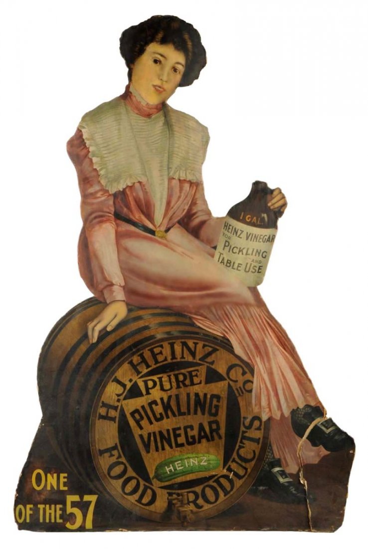 Early Heinz Vinegar Diecut Advertising Sign.: The is a large sign advertising Heinz Pure Pickling Vinegar. It shows a woman dressed in Victorian garb sitting on a Heinz wooden barrel. There is a moderate amount of restoration to this sign. The bo