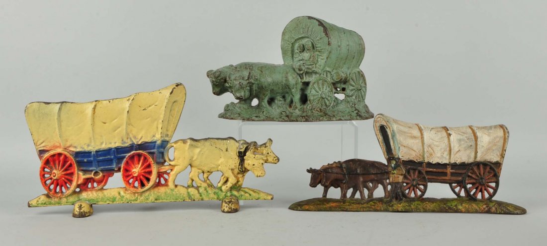 Lot of 3: Cast Iron Conestoga Wagon Doorstops.: Candlestick Co., Hubley, etc. One is combination lamp doorstop.