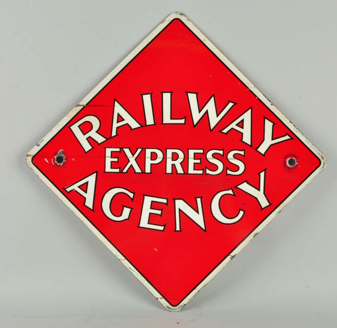 Railway Express Agency Sign.: A red and white diamond shaped Railway Express Agency sign. The background is red while the boarder and lettering is white. Nail holes present with scratches, and paint deficient areas.