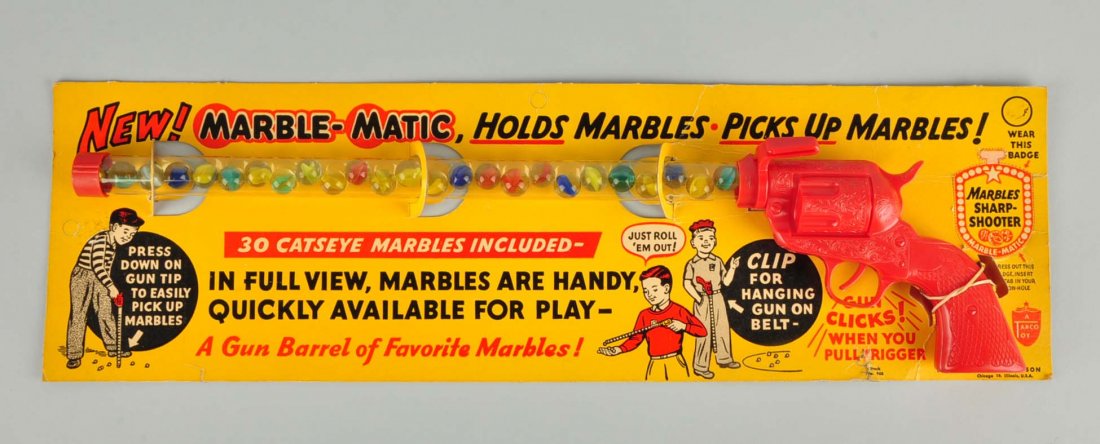 Marble-Matic Marble Holder Gun.: Plastic sharp shooter gun that holds and picks up marbles. Includes 30 catseye marbles. Circa 1950's. In the original packaging.