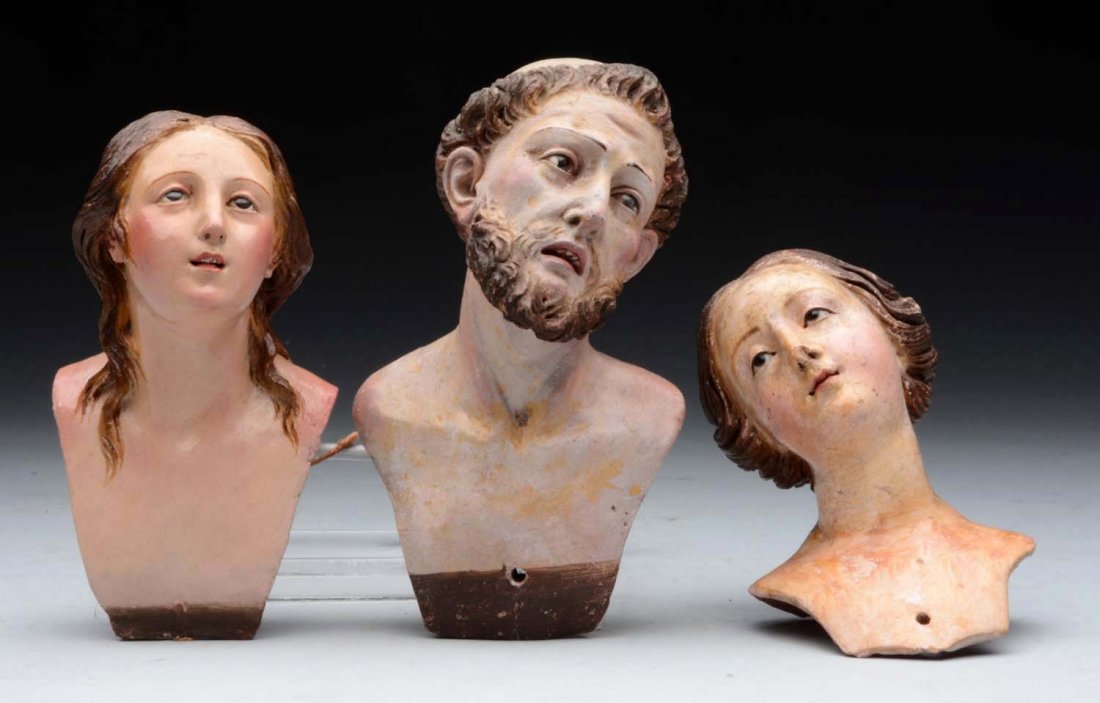 Lot of 3: Crèche Figure Heads.: Two terra cotta women with beautifully modeled faces, featuring inset eyes and molded hair with lovely ethereal expressions (nose flake and overall soil on one); male figure with inset eyes, molded op