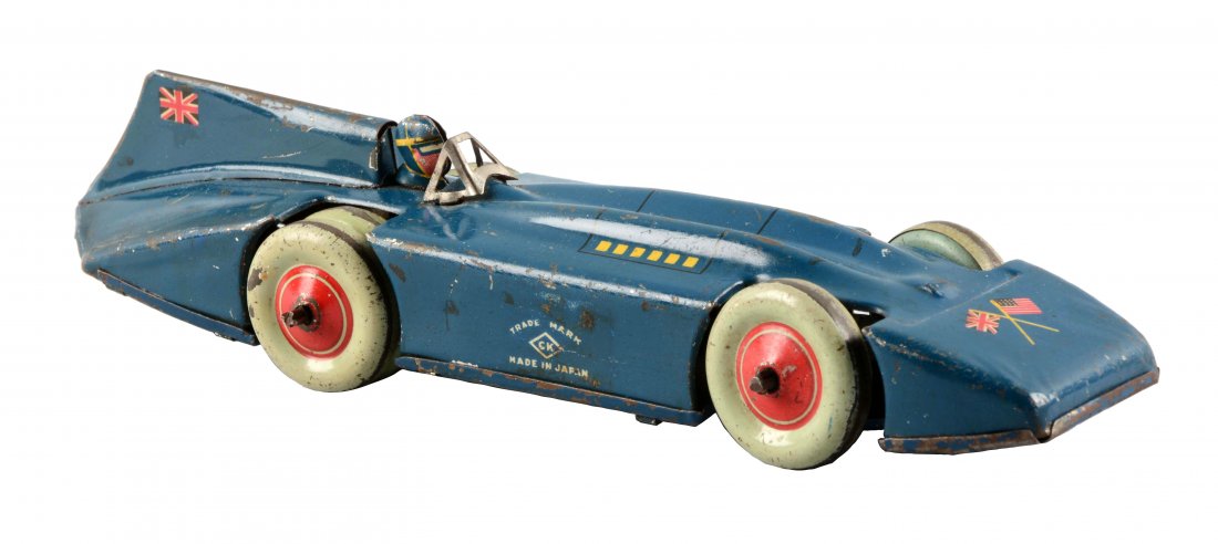 Pre War Japanese Tin Litho Blue Bird Race Car.: Wind up on the bottom. Marked "CK". English and American flags on the on the front of the car and the rear fin. Dual wheels in the rear. Moderate general scratching and wear. (Very Good). 8 -1/2" L.