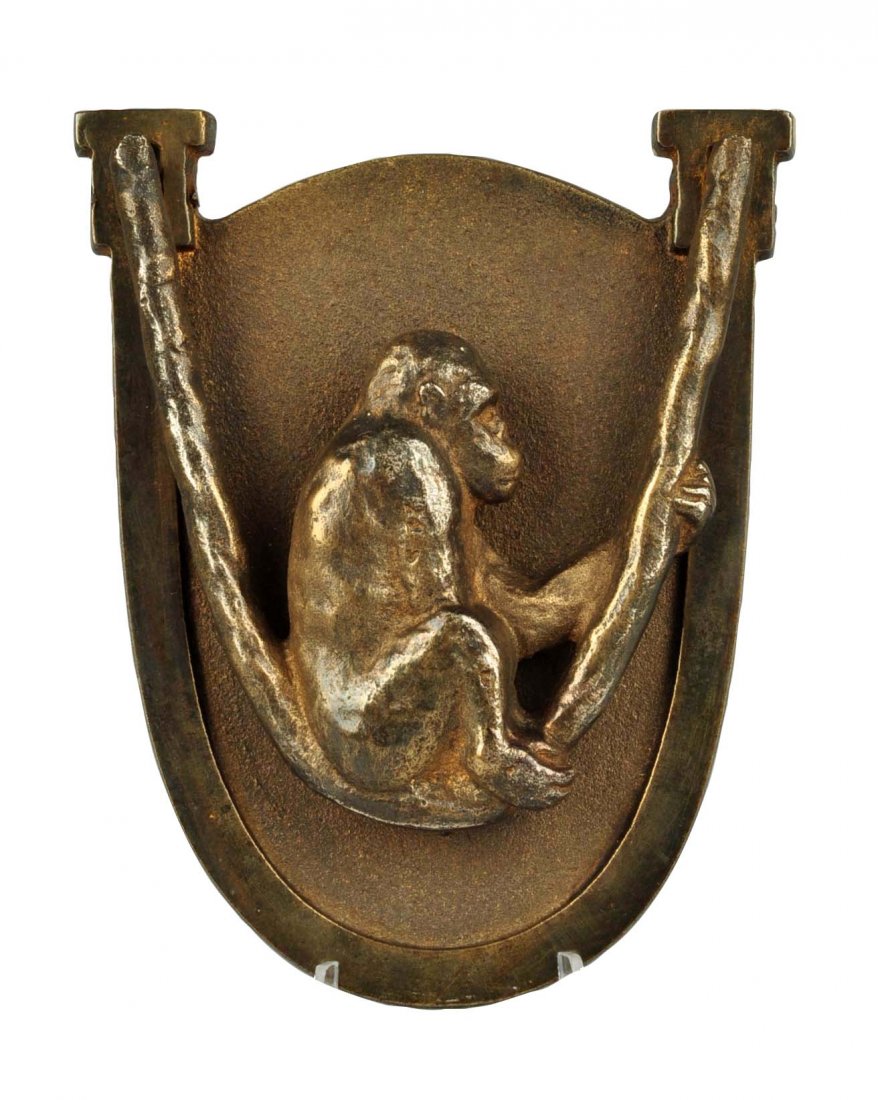 Cast Iron Monkey in Swing Doorknocker.: Made by Hubley. Shows profile of monkey sitting in swing which is the clapper. Brass electroplated over cast iron. (Excellent). 4-1/4'' L.