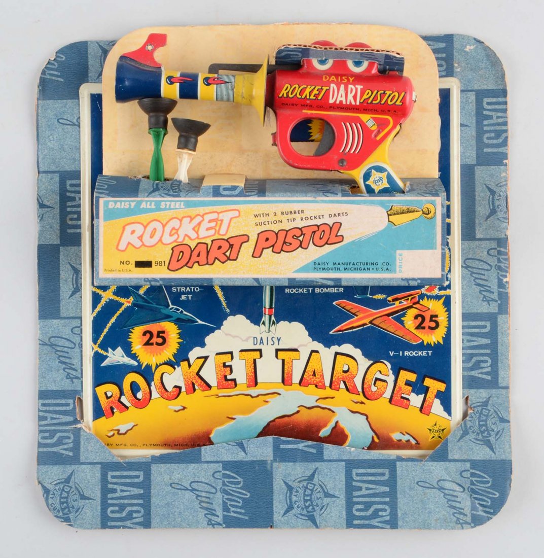 Scarce Daisy Tin Litho Rocket Dart Pistol.: Looks to be the same pistol as a small version Buck Rodger's pistol. Comes with two original darts. Nice tin litho board with space design. Includes original cardboard header. Some creasing and where 