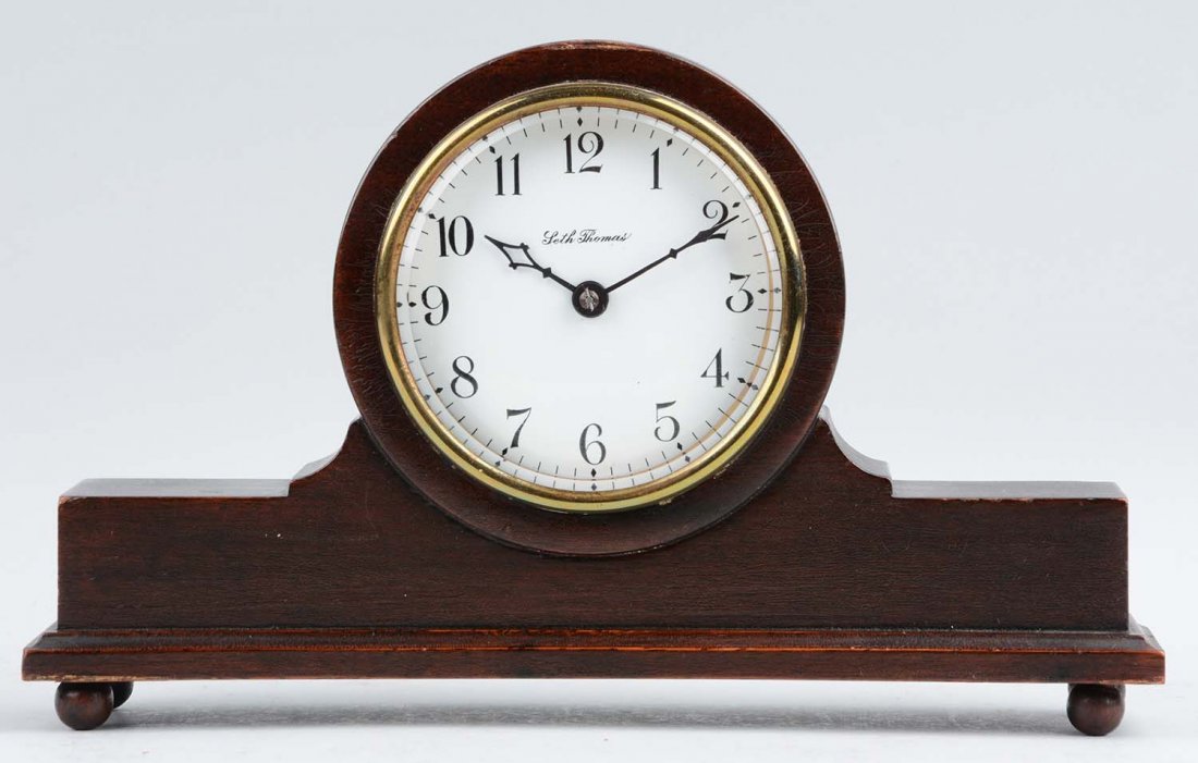 Seth Thomas Bolton Clock.: This lot is of a Seth Thomas Bolton clock. The clock is comprised of a dark wooden body with a white face and black numbers. Scratches, nicks and wood deficient areas are present, along with some craz