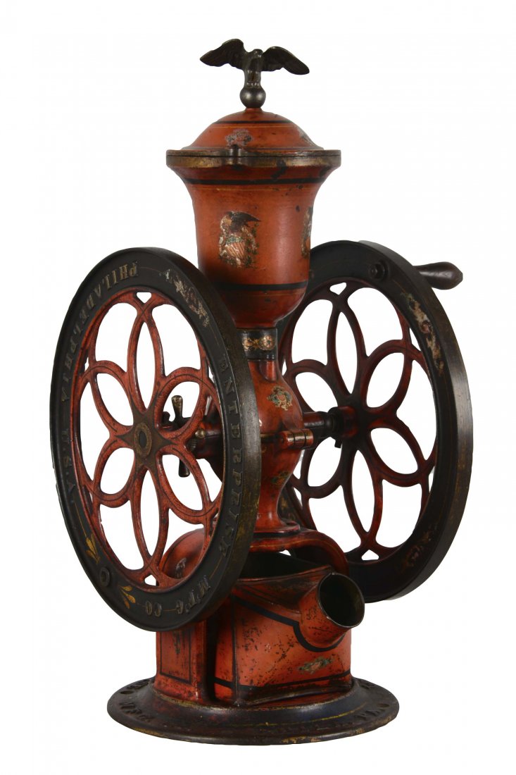 Enterprise No.512 Coffee Grinder: Constructed almost entirely of cast metal, save for the wooden handle on one of the wheels. Each wheel is marked "Enterprise M'F'G' Co./ Philadelphia U.S.A." and the front of the hopper is marked "512