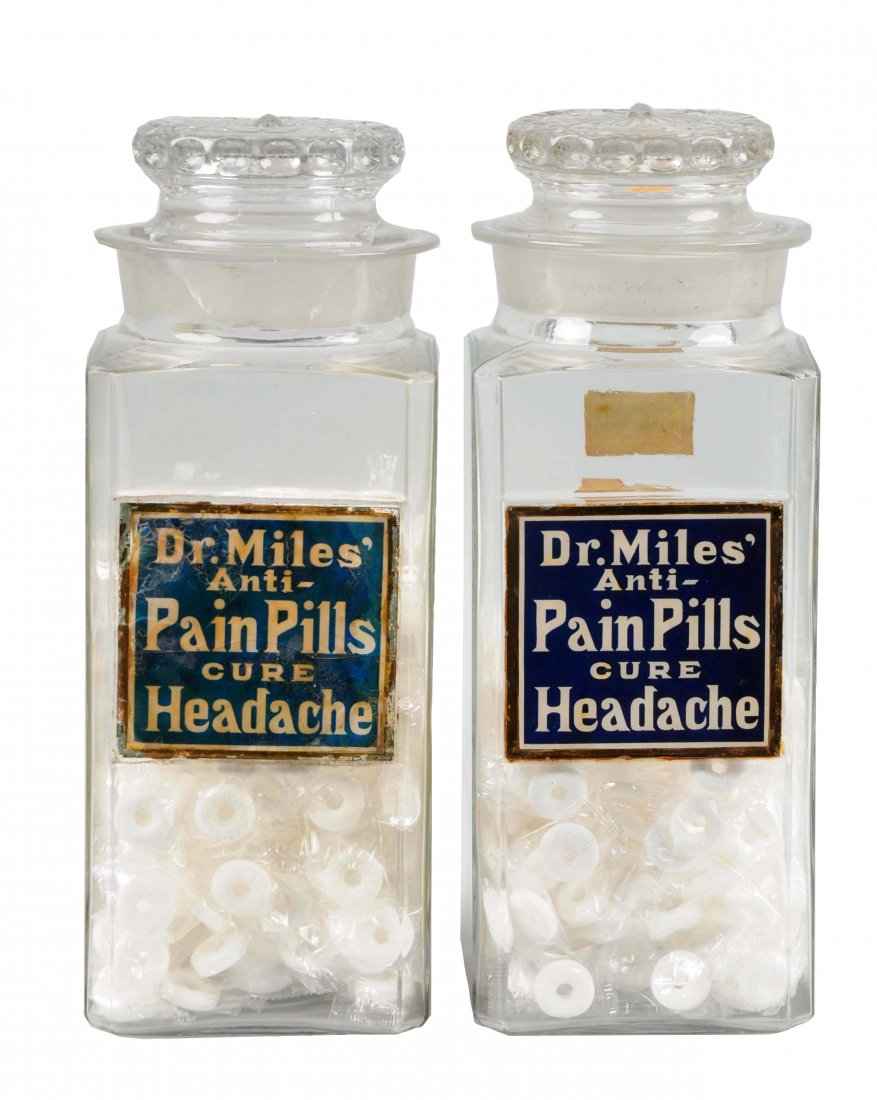 Pair of Dr. Miles Pain Pills Apothecary Jars.: Both jars retain their original reverse on glass labels and original lids. One of the jars is in excellent condition with a clean label and one small chip on the lid. The other jar has a cracked label