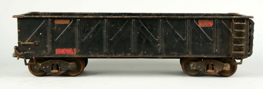 Pressed Steel Buddy L Gondola.: Buddy L decal on the bottom. Rust on the wheels, axles and trucks, missing both couplers, scratches and paint chips, paint loss in the bed of the gondola and some rust. (Good). 20-1/2'' L.