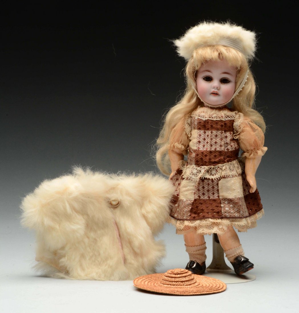 Small Kestner 143 Child.: Bisque socket head incised "Made in Germany 143" having brown glass sleep eyes, open mouth with upper teeth, on the original fully jointed wood and composition body with straight wrists, wearing a lov