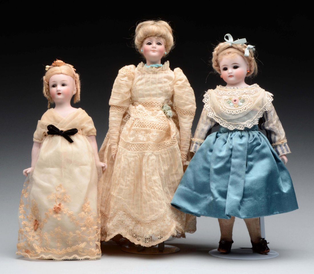 Lot of 3: Small German Bisque Head Dolls.: The tallest is a Kestner Gibson Girl incised in the back of the head "172 Made in Germany" with closed mouth, blue glass sleep eyes, protruding chin. Shoulder plate mounted to a cloth body with bisque