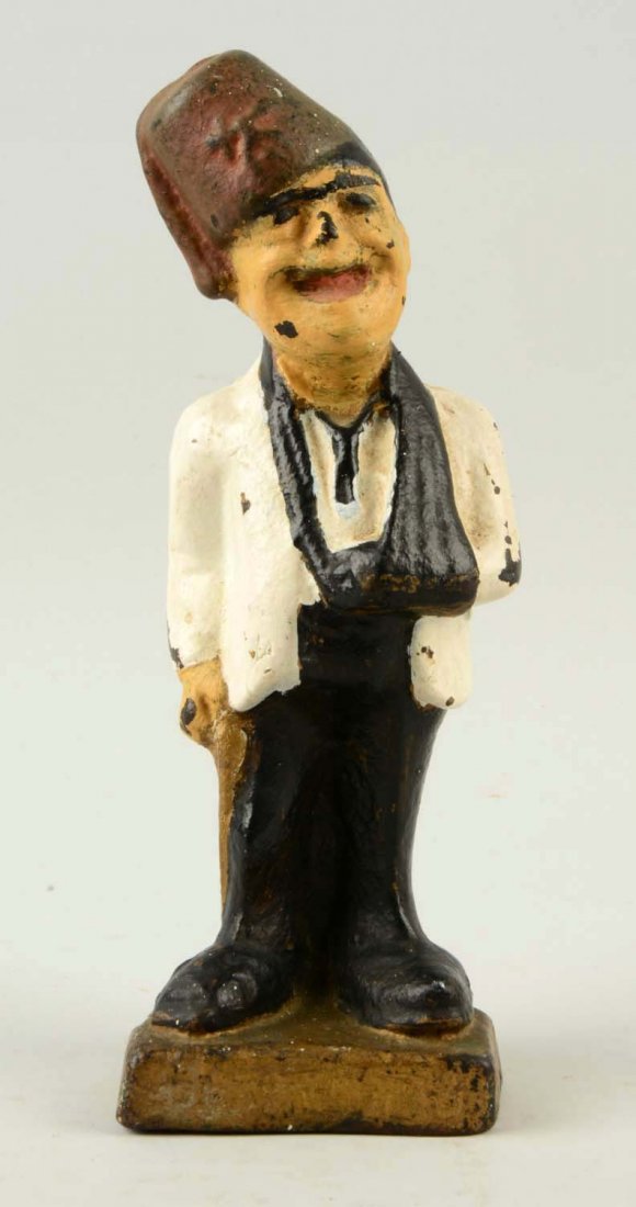 Cast Iron Man Wearing Fez Hat Doorstop.: Depicts man wearing fez hat with arm in sling. Touch up to paint. (Very Good). 10" T.