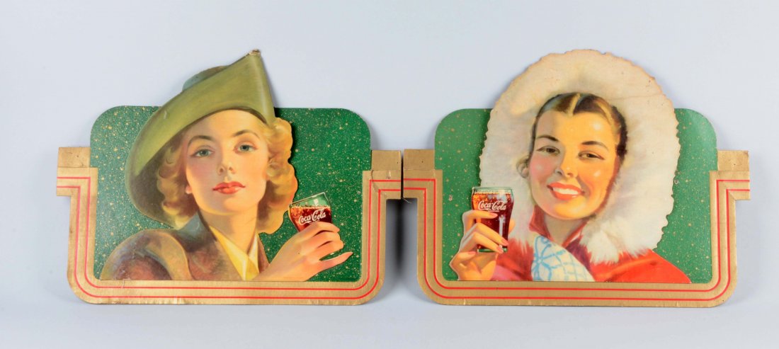 Lot Of 2: 1944 Coca-Cola Diecut Advertising Signs.: Both signs show woman enjoying glasses of Coca-Cola. There is some moderate soiling, added holes, scattered edge wear and fold marks. (Good - Very Good). Each: 20-1/2'' x 15-1/2''.