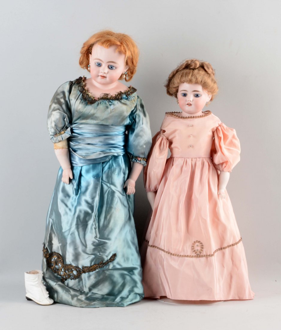 Lot Of 2: Simon & Halbig Shoulder - Head Dolls.: The larger doll in the long blue silky dress has inset blue glass eyes, an open smiling mouth with upper teeth, pierced ears, and is incised on the back of the shoulder plate "S&H 1010". She is on a l