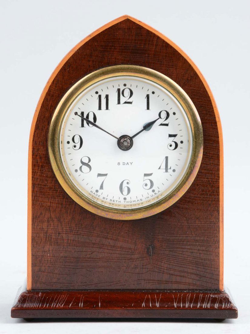 Seth Thomas "Como" Clock: This lot is of a Seth Thomas "Como" clock. This clock has a white face with black numbers. The body of this clock is comprised of a dark wood with a lighter wood inlay. On the face, it notes that this