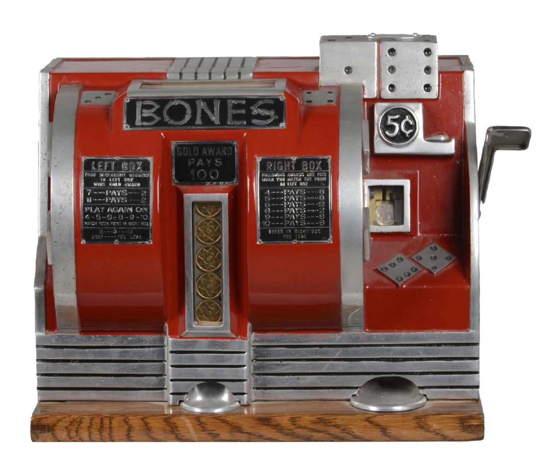 **5¢ Buckley Bones Countertop Dice Slot Machine: Bones is a clever machine to play Craps. The cast aluminum cabinet is a work of art and in great condition showing an older restoration. One key is included. Circa 1936. (Very Good - Excellent). 13-1/