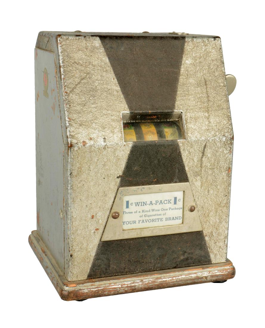 **1¢ O.D. Jennings Win-A-Pack Trade Stimulator: This three reel machine advertises for cigarette rewards and has cigarette reel strips. In working order. Cabinet shows paint loss throughout. Includes key. Circa 1934. (Good). 9" x 7-1/2" x 12".