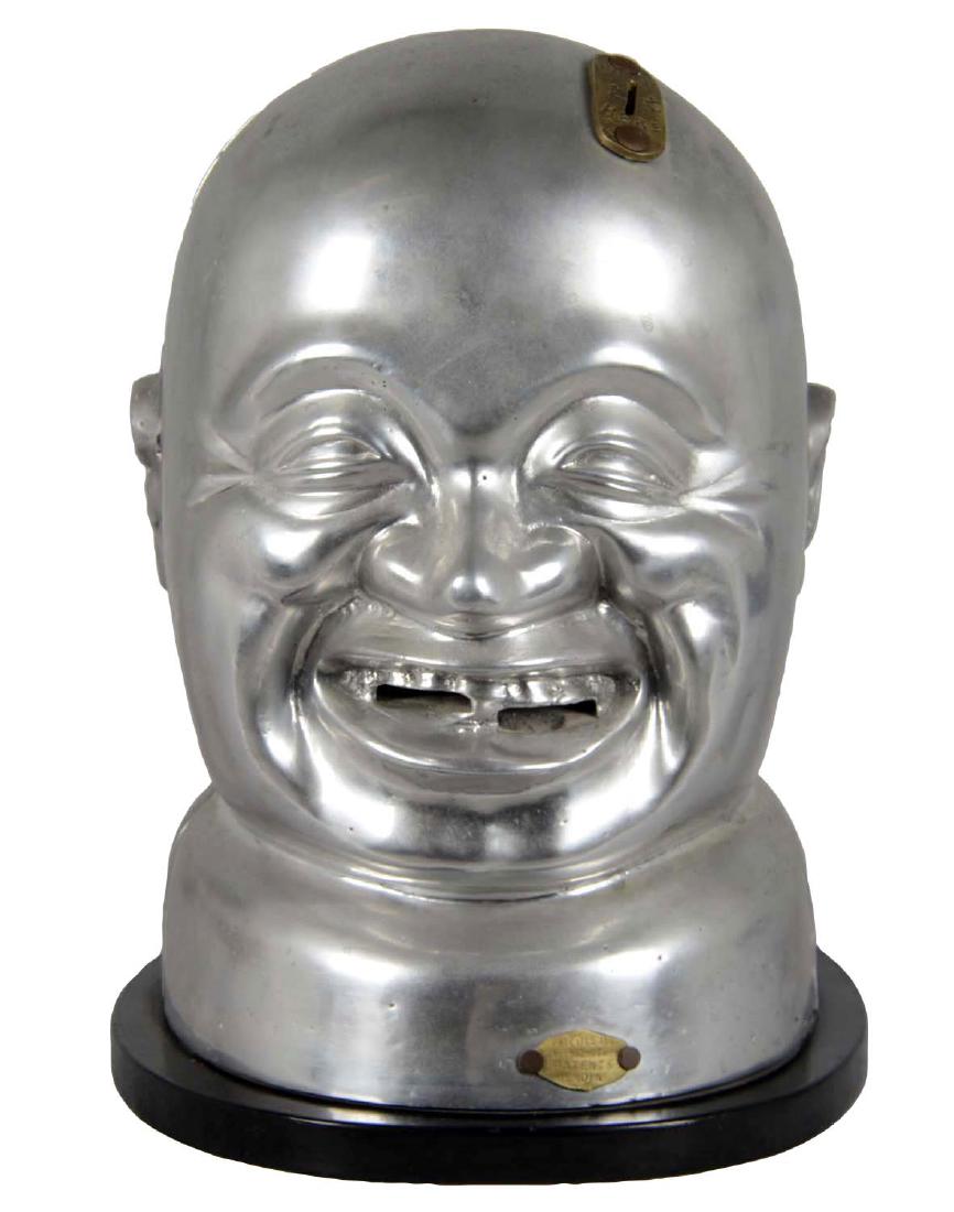 1¢ "Happy Jap" Gum Vending Machine: Unpainted metal on a wood base with flat coin entry. Originals by White Vending Machine Co. circa 1902 were cast iron and painted with a mustache, toothy grin, and thick eyebrows. Casting shows a 1" c