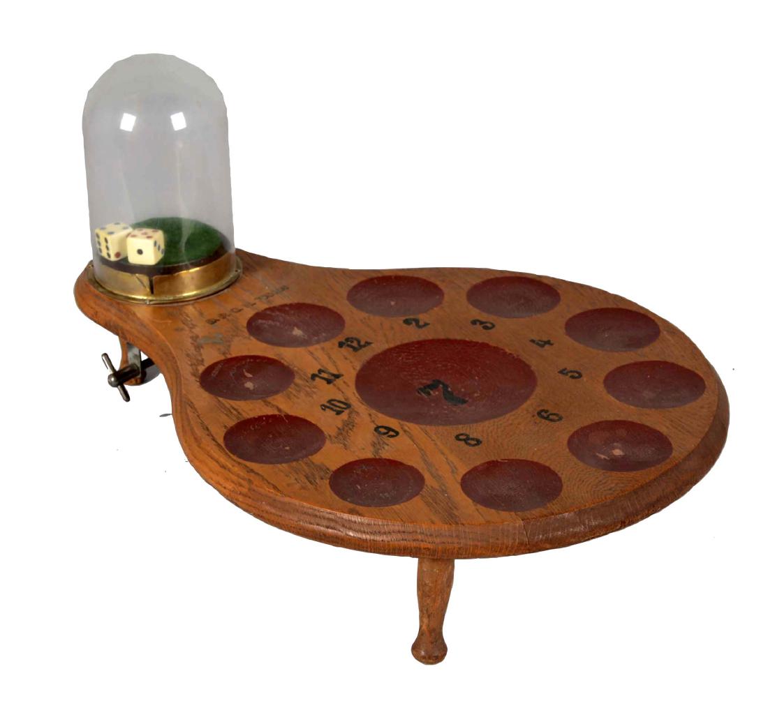 Dice Game Monaco: Wooden game board with 11 red wells to place bets and clear glass dome with dice inside. The knob on the underside shakes the dice when turned. Instructions for game play are posted on the underside o