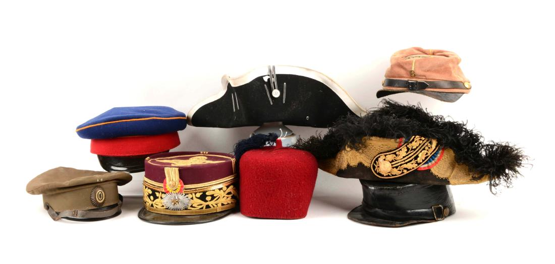 Lot Of 8: Reproduction & Original Military Hats.: Includes a black leather kepi. Black chin strap, two flat brass buttons, black visor. Shows use, scratches with missing lining; a reproduction French style red kepi with black trim, gold leaves, acorn