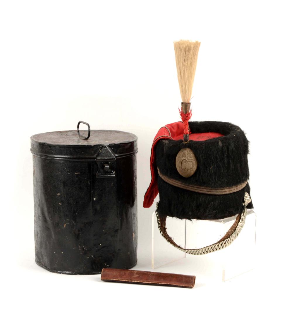 Late 19th Century Busby.: Black bear busby with scarlet top and bag. Silver soutache edging. It has lining and sweat pan with silver chain chin strap. Letters "RJ" in the lining. Original Japanned tin carry on case, top handle