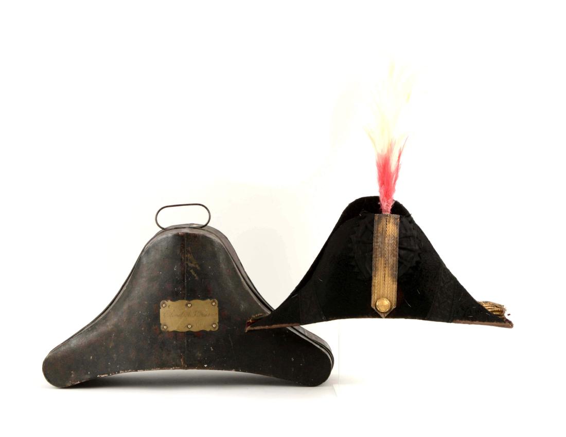 Identified British Military Chapeau in Original: Circa 1830-50's. Black beaver chapeau with black ribbon tassels, black rosette, and gold bullion trim. One gilt button, red and white plume on baleen stem. Interior lining and sweat pan. Shows wear on