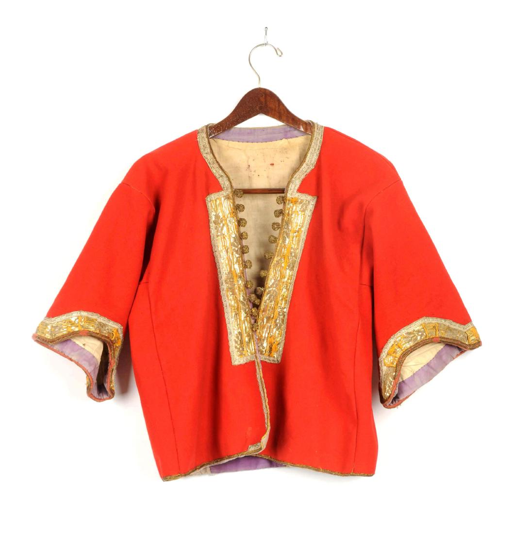 Russian Ethnic Jacket with Half Sleeves.: Red heavy wool waistcoat with silver and gold metallic tinsel trim. Two areas with front bullion tape edging and floral design. White lining with purple trim and one pocket. Very good condition with a