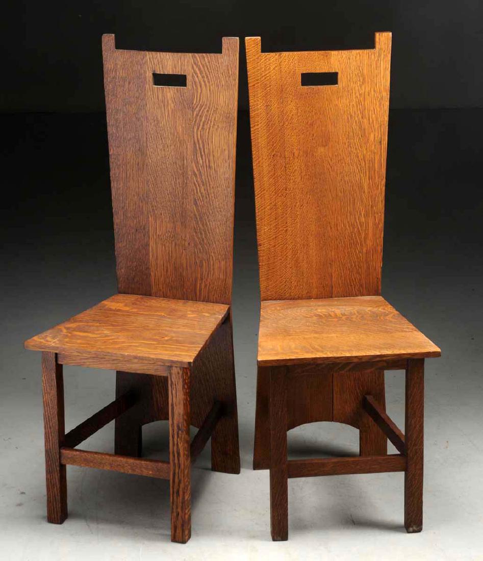 Pair of Prairie Style Plank Chairs with Cutouts.: Style of Frank Lloyd Wright. Made of quarter sawn oak, pinned. Unsigned. Refinished. Signs of wear consistent with age and use with some light scratches to the seats and slight seam separation to one.