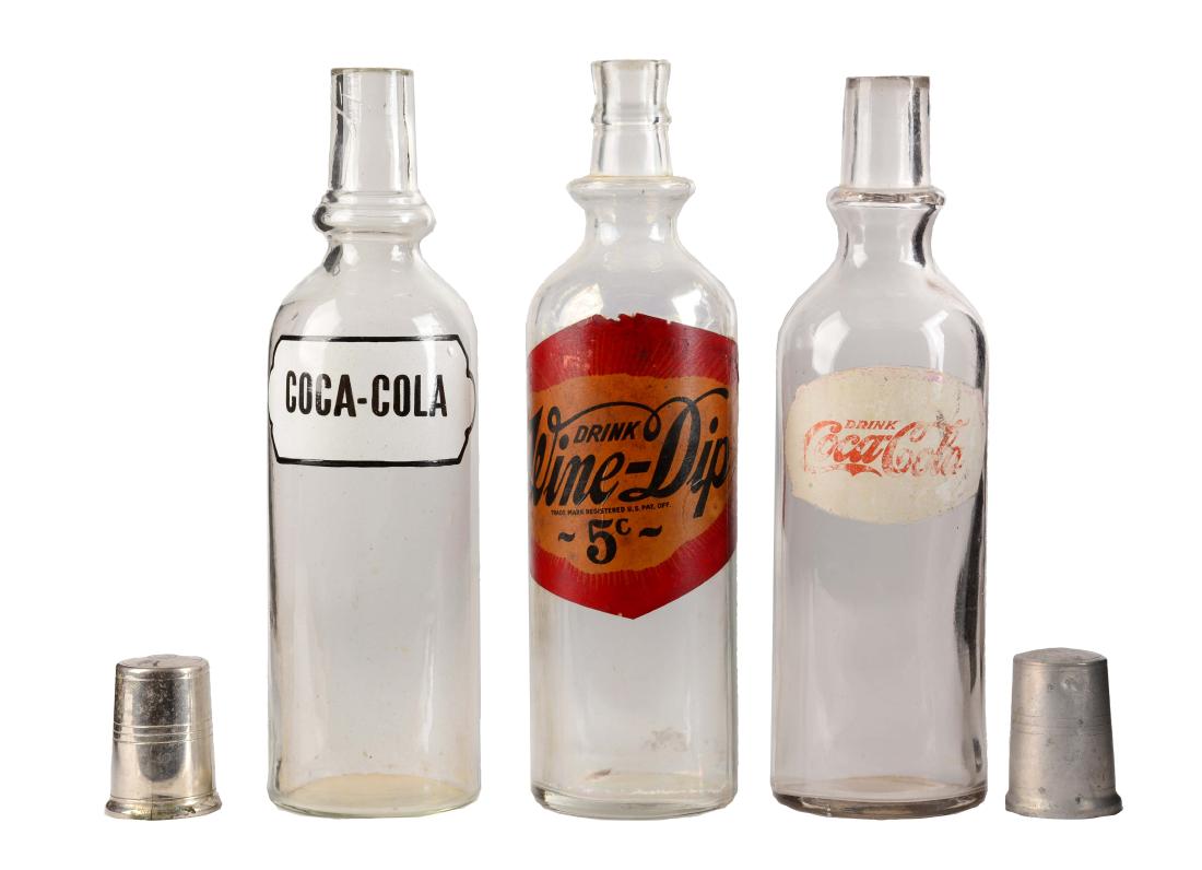 Coca - Cola & Wine Dip Syrup Bottles.: Included in this lot are two early Coca-Cola syrup bottles. One has a rather worn label while the other is very strong with almost no wear. Both Coca-Cola bottles come with tops. The Wine Dip bottle h