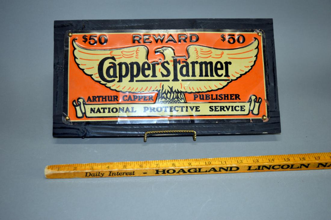 Capper's Farmer enameled metal sign: Minor surface wear and rust; mounted to wood frame