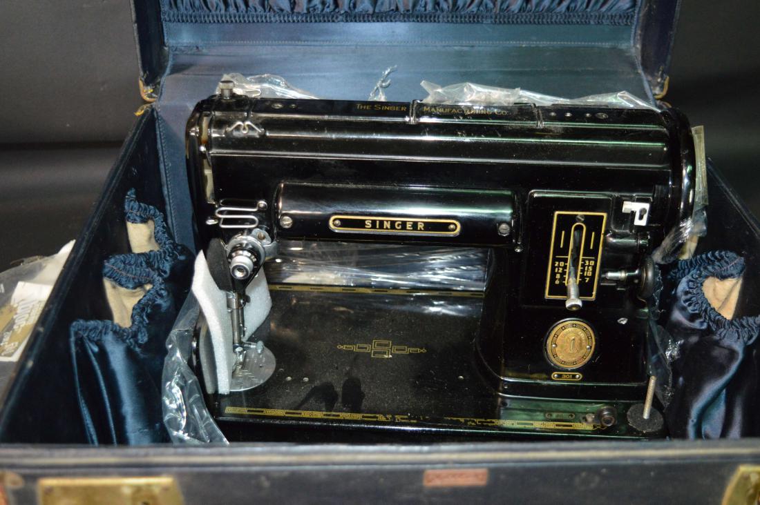 Singer 301A Sewing Machine: A Singer 301A sewing machine, together with a Leeds suitcase. Wear commensurate with age. Please review the images for condition and dimensions.