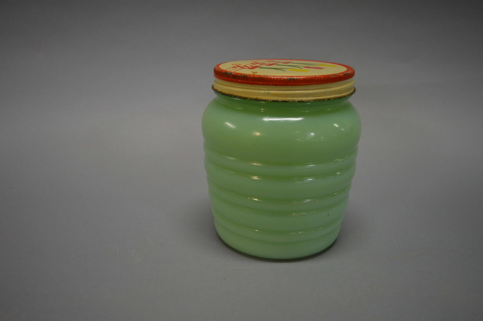 A Jadeite Glass Grease Jar: An Anchor Hocking Jadeite glass grease jar, with original lid. Good condition with minor lid wear. It measures 4.25 inches tall. Please review the images for condition and dimensions.