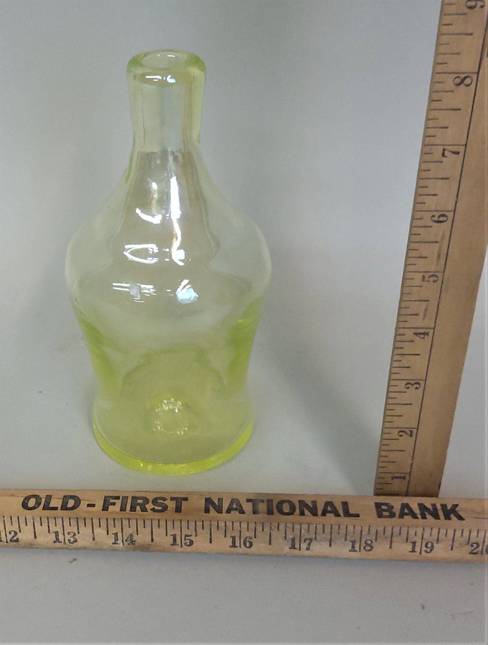 Gibson Vaseline Glass Bottle: A Gibson vaseline glass bottle.