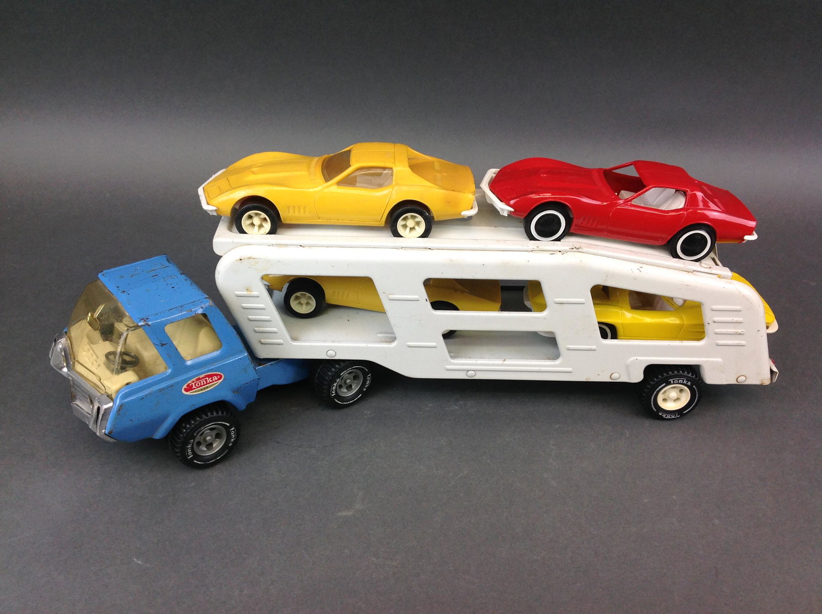 Tonka Car Transport Truck & Trailer: A Tonka car transport truck and trailer, with four plastic cars.